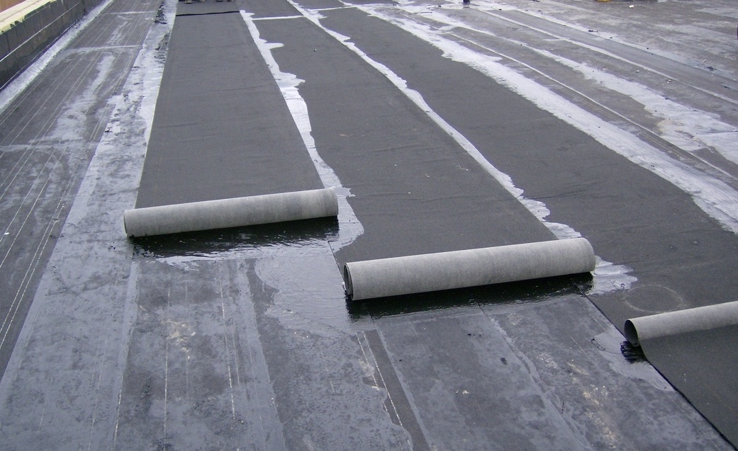 Flat Roof Installation With Worker Heating & Melting Bitumen Roofing Felt By a Flame Torch