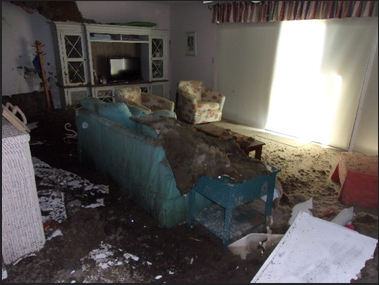 Bedroom with ceiling debris fallen on bed due to leaking roof and water damage