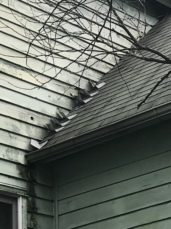 Residential Roof Replacement 12 Botched flashing and siding is too close to the shingles. You can see the damage under the eaves