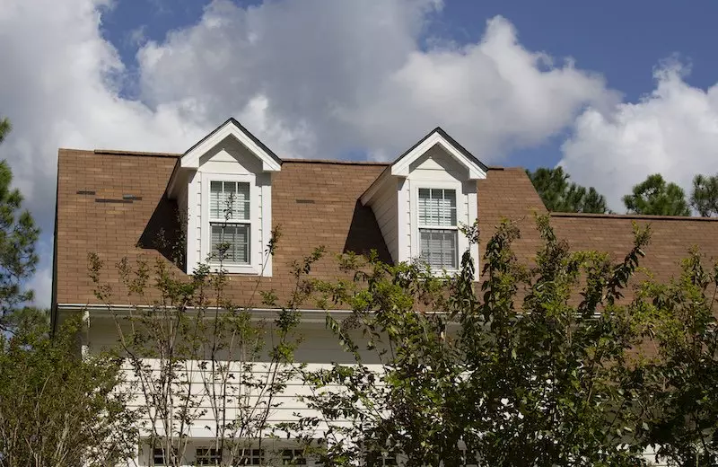 Home with 3-tab roof that has missing shingle tabs and wind damage all over roof