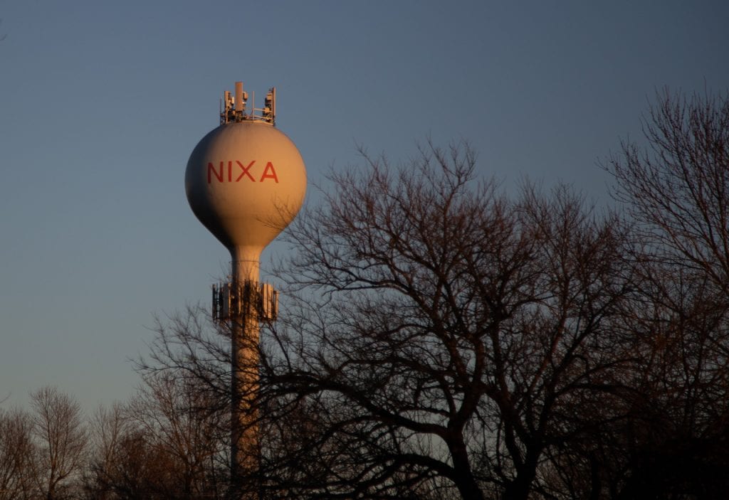 Water tower in nixa at sunset with trees