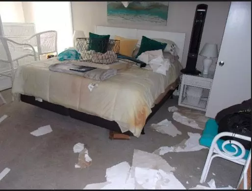 Bedroom where ceiling fell onto bed, from water damage