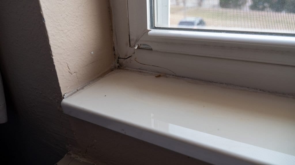 Window with cracked drywall from wind